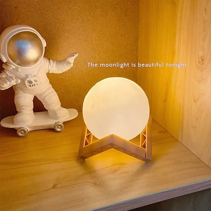 Astronaut decorative piece next to a warm light moon lamp with wooden stand displayed on a shelf or cabinet