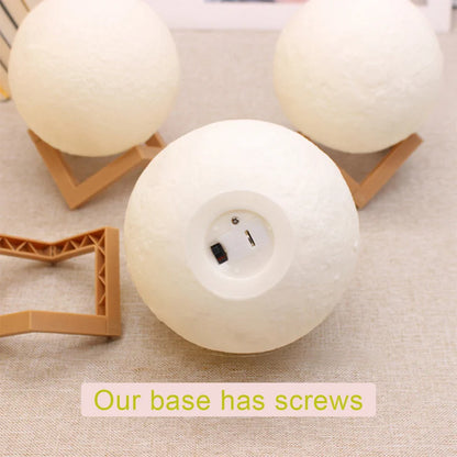 Three moon lamps on a table, two with wooden stands turned off, one lamp without stand showing the base, highlighting the lamp’s base feature